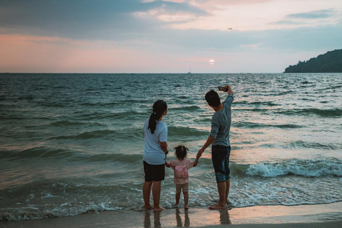Родители с ребенком на берегу моря